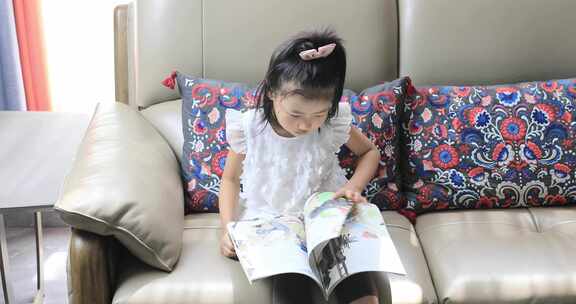 小女孩坐在沙发上看书