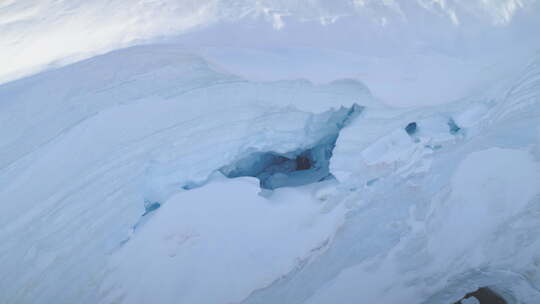 南极半岛白色冰川中的蓝色冰洞航拍特写