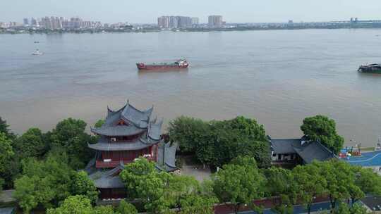 沿江道路边绿树中的古建筑风景九江锁江楼