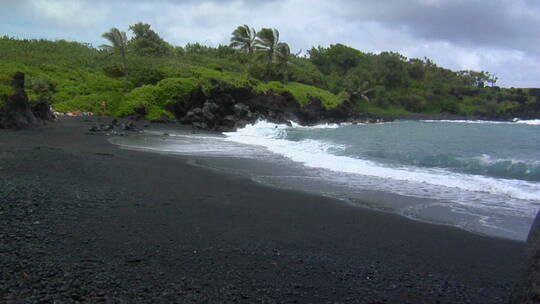 海浪冲击夏威夷的黑色沙滩