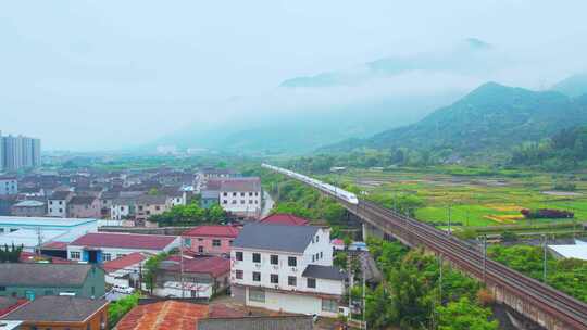 航拍雨后云海中的中国乡村高铁
