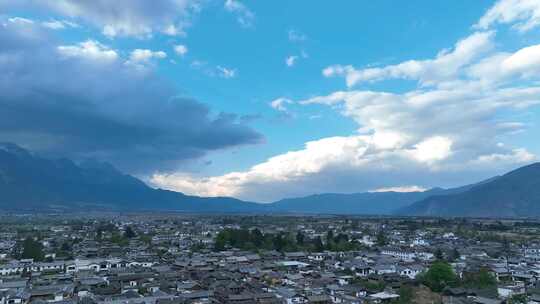 4k航拍左移雪山白沙古镇远景与山峦云彩