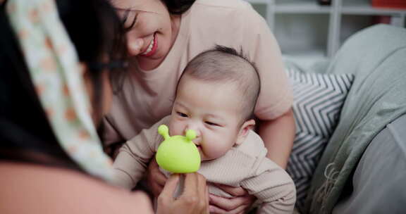 两个女人在家里客厅的沙发上开心地和一个小