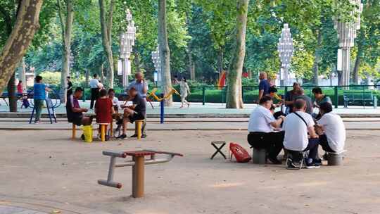 悠闲时光，在公园林荫下打牌下棋的老人们