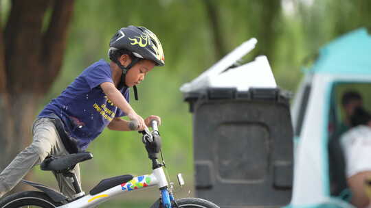 周末戴头盔的孩子在公园骑自行车