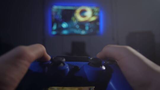 玩家双手在宽屏广场电视前手持操纵杆的视角拍摄