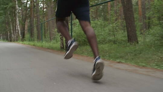 男人在林间公路上奔跑腿部特写视频素材模板下载