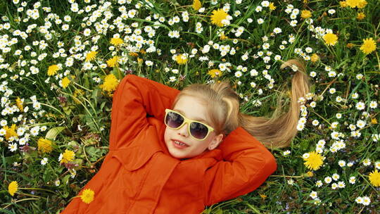女孩躺在花丛里竖起大拇指
