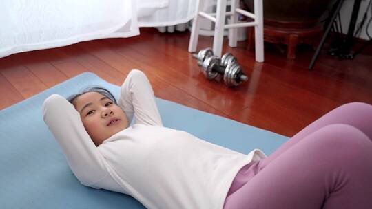 做仰卧起坐锻炼的亚洲女孩视频素材模板下载