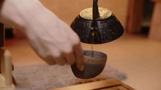 手用茶壶倒茶近景