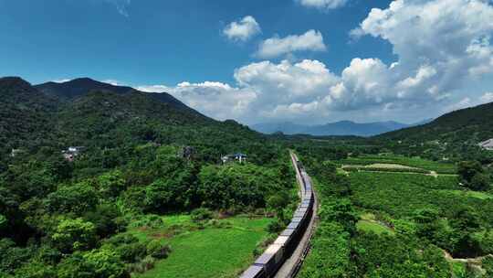 蓝天白云阳光下桂林山区铁路上的货运列车