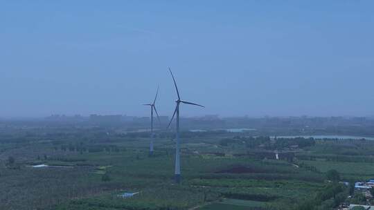 村镇绿色庄稼地树林风力发电大风车环绕横移