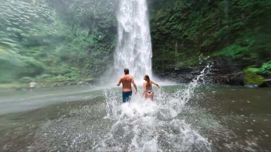 情侣在瀑布下玩水海岛度假村度假酒店