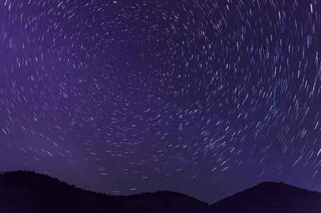 夜空繁星与远处灯火景观