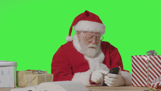 圣诞老人在绿色屏幕前使用手机