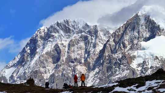 航拍垭口观看贡嘎山区雪山群峰的徒步旅行者