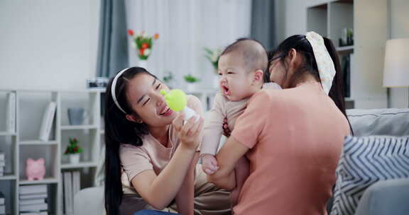 两个女人在家里客厅的沙发上开心地和一个小