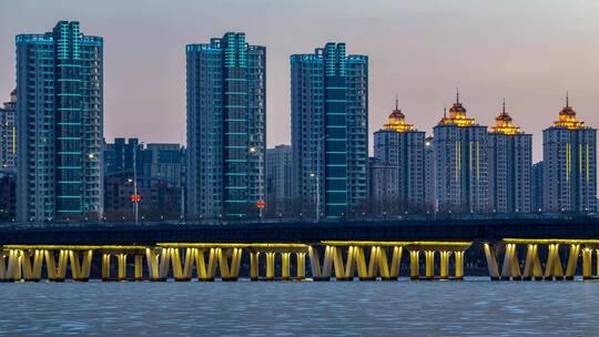 浑河大桥冬季北方冰河上的建筑白天到夜晚