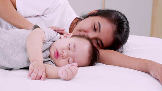 妈妈和婴儿睡在一起午睡。白天母亲和婴儿在床上睡觉