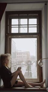 窗台上喷洒保湿霜的女人竖屏