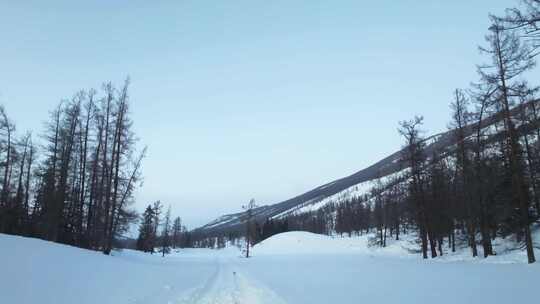 冬季喀纳斯湖雪山脚下汽车在积雪路面上行驶