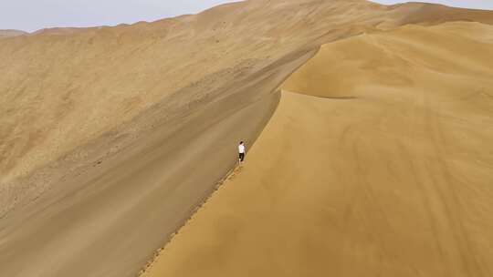 航拍沙漠沙脊上行走的人