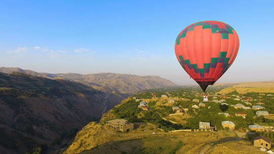 热气球飞越村庄视频素材模板下载