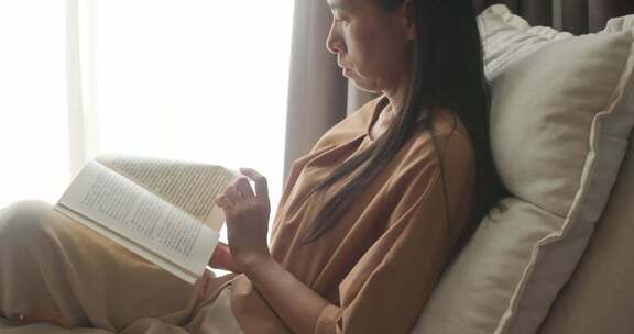 女性室内沙发上阅读书籍