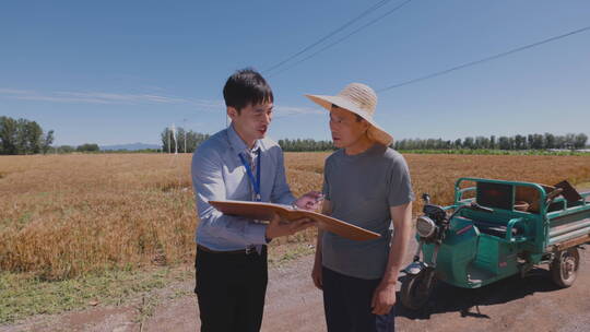 科研人员和农民在麦田里交流技术