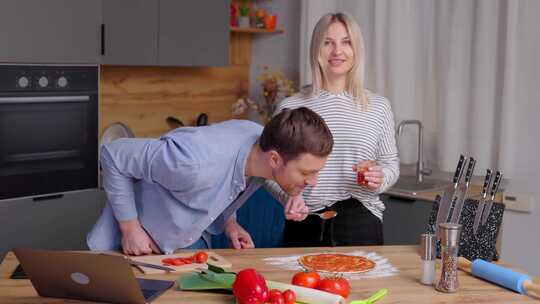 浪漫的夫妇正在厨房做饭。英俊的男人和迷人