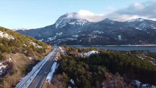 汽车行驶在山和湖间的公路上