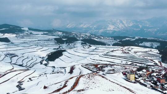 冬季白雪覆盖山川田野农村远处连绵雪山