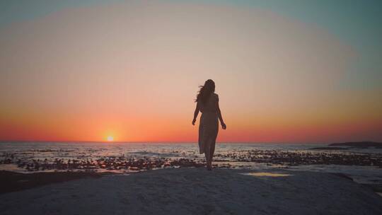 美女站在海边看日出看夕阳看日落看风景背影
