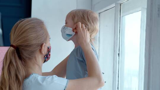 母亲帮婴儿佩戴好口罩视频素材模板下载
