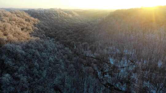 航拍落满积雪的山峰迎来日出余晖