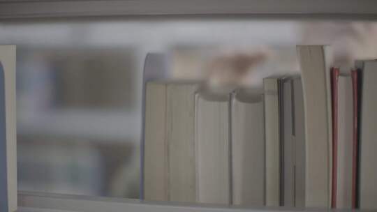 书架上找书的老人视频素材模板下载