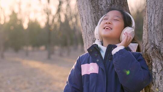 4K实拍冬日暖阳带耳机欣赏音乐的东方女孩