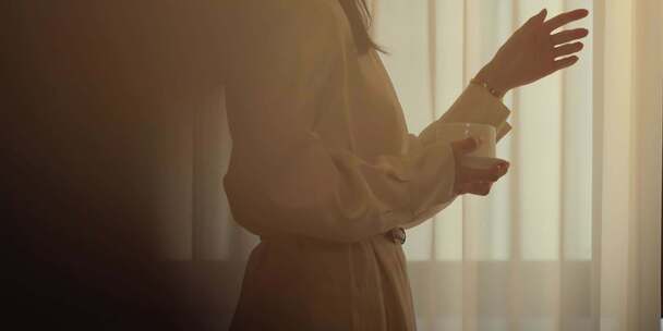 女子窗前手持杯盏动作特写