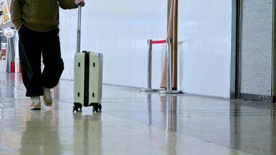机场中拖着行李箱行走的游客