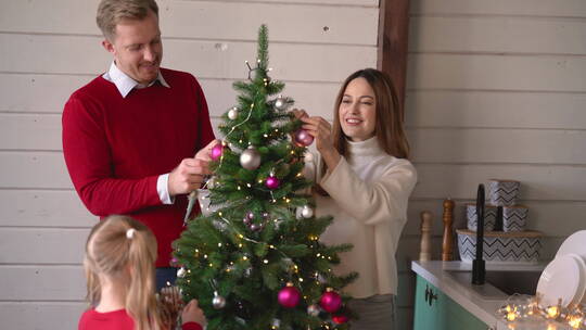 父母和女儿一起装饰圣诞树