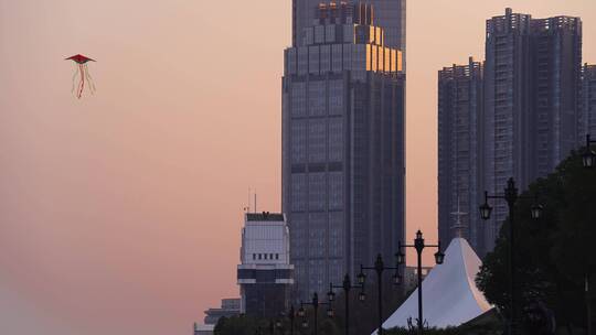 傍晚城市高楼天空飞风筝高楼夕照