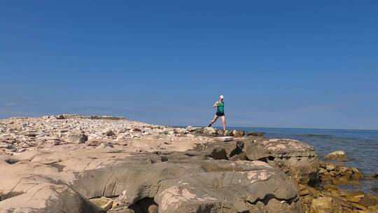 女人在海岸岩石上行走