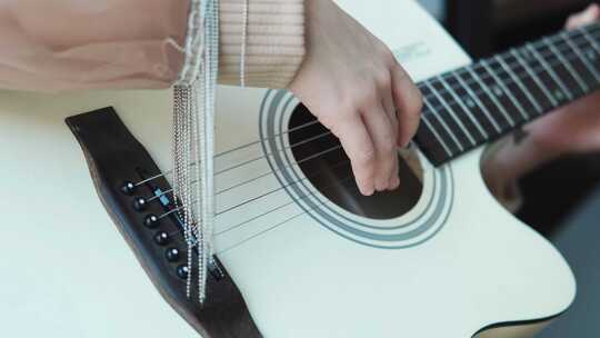 一个女孩弹吉他弦的特写镜头