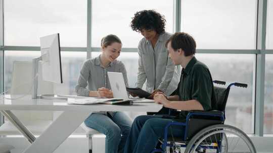 轮椅上的人与同事讨论工作问题成功多元化的
