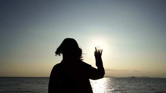 美女站在海边向太阳挥手女人招手开心挥手