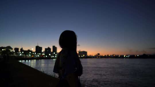 夕阳下的海边女人背影