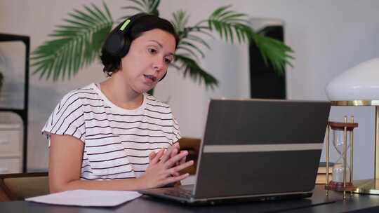 女人戴着耳机参加电脑会议视频素材模板下载