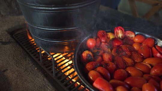 在传统厨房用木火烹饪西红柿。