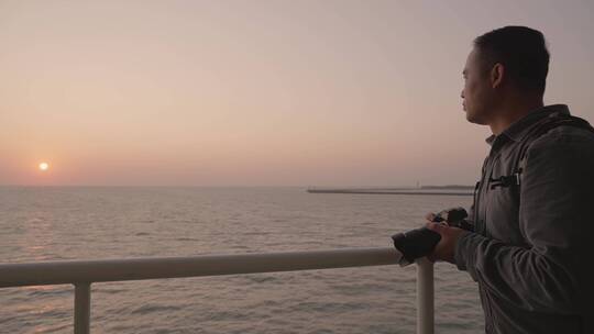 摄影师在轮船甲板上拍摄海上夕阳视频素材模板下载