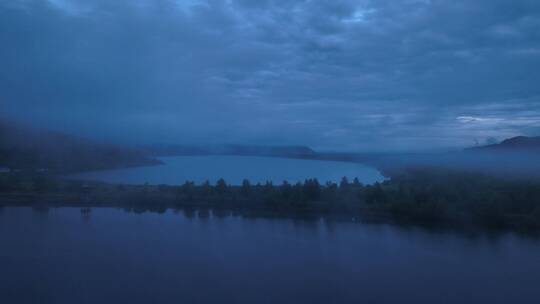 航拍晨雾迷漫的蓝色湖泊